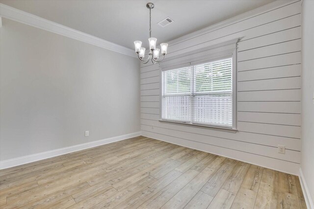 unfurnished room with crown molding, light hardwood / wood-style flooring, and a chandelier