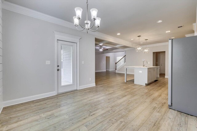 interior space with ceiling fan with notable chandelier, light hardwood / wood-style floors, crown molding, and sink