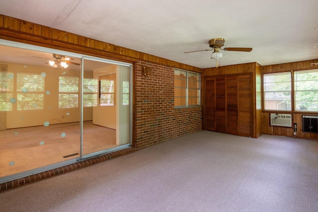 3437 Rushing Rd, Augusta, GA 30906 - spare room featuring carpet flooring, a ceiling fan, brick wall, and wood walls
