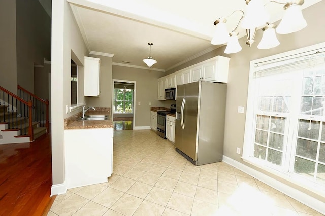 kitchen featuring pendant lighting, sink, white cabinetry, stainless steel appliances, and ornamental molding