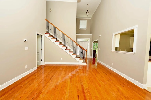 foyer entrance with a towering ceiling and light hardwood / wood-style floors