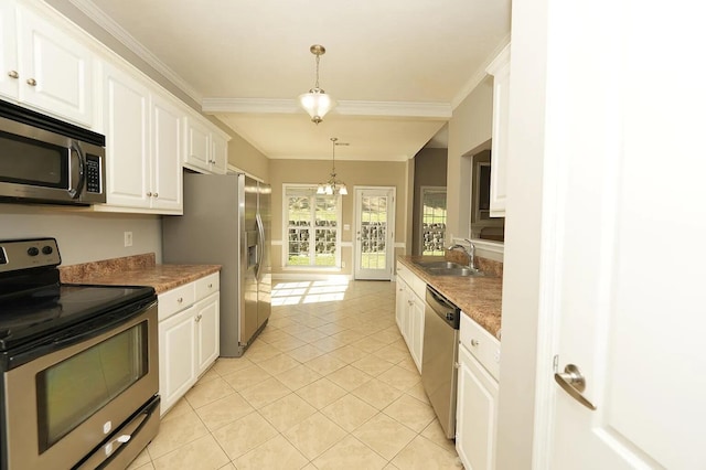 kitchen with pendant lighting, sink, stainless steel appliances, and white cabinets