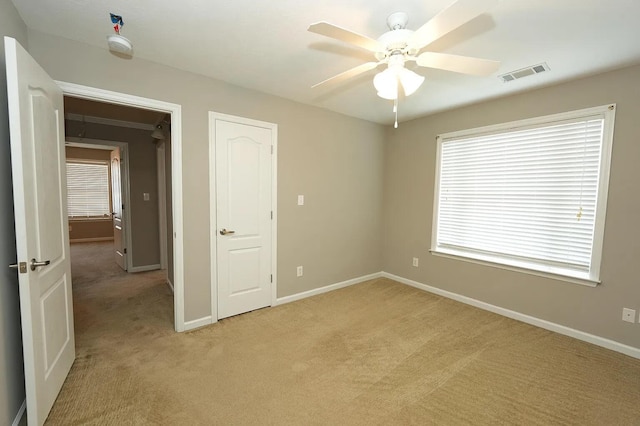 unfurnished bedroom with light carpet and ceiling fan