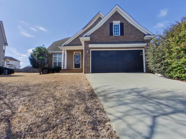 view of front of property with driveway, an attached garage, fence, and brick siding