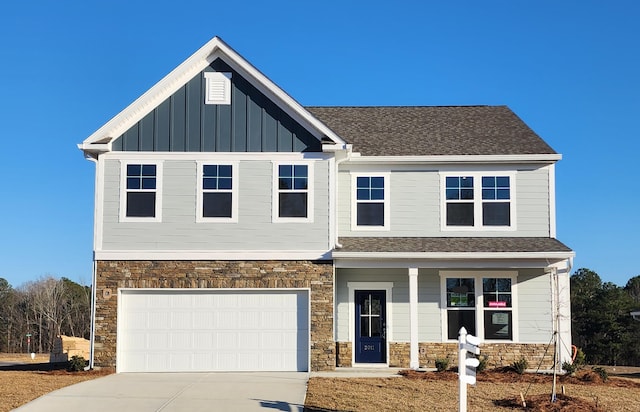 view of front facade featuring a garage, driveway, a shingled roof, stone siding, and board and batten siding