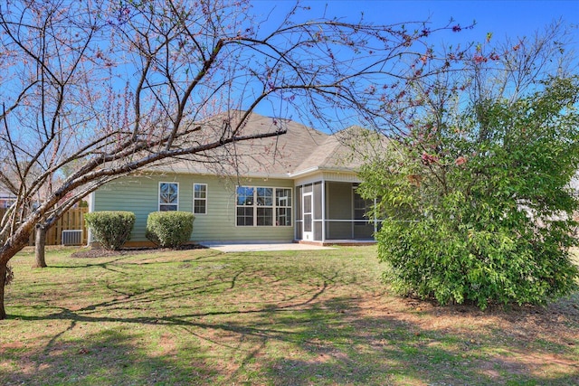 back of property featuring a sunroom, central AC unit, and a lawn