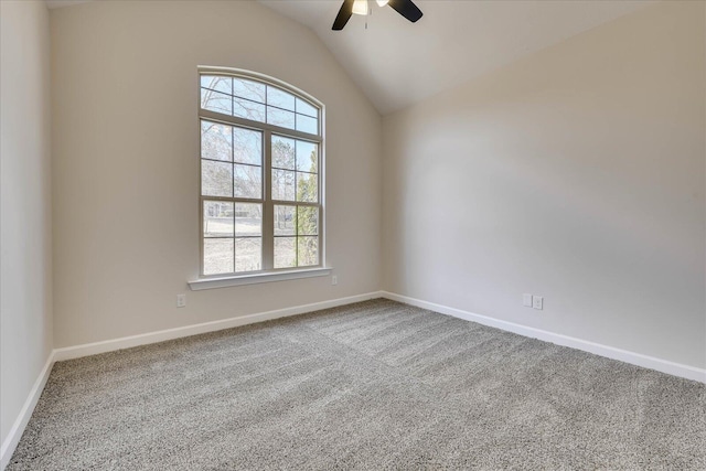 carpeted empty room featuring vaulted ceiling, baseboards, and ceiling fan