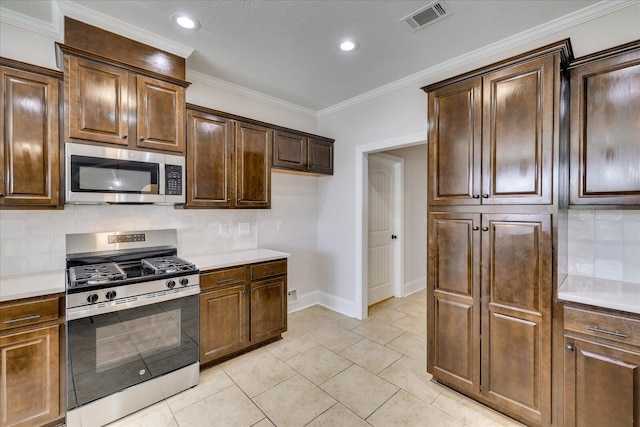 kitchen featuring tasteful backsplash, visible vents, ornamental molding, stainless steel appliances, and light countertops