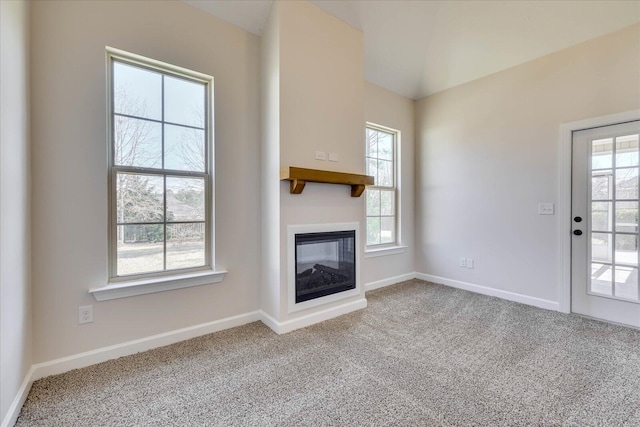 unfurnished living room with carpet floors, plenty of natural light, baseboards, and a multi sided fireplace