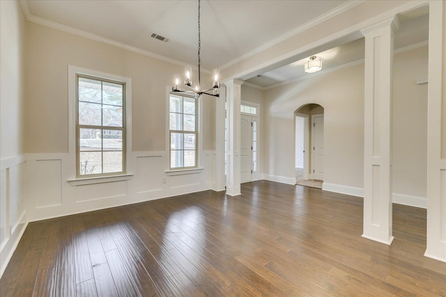 unfurnished dining area with arched walkways, wainscoting, visible vents, and hardwood / wood-style floors