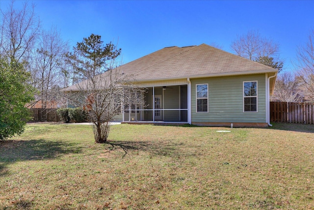 back of property featuring a sunroom, a shingled roof, fence, and a yard