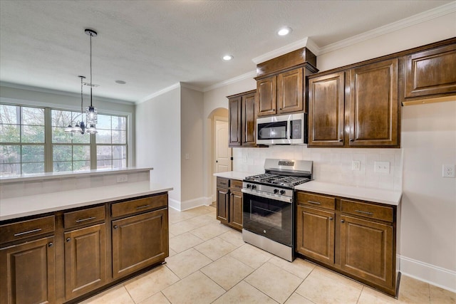 kitchen featuring arched walkways, stainless steel appliances, light countertops, backsplash, and decorative light fixtures