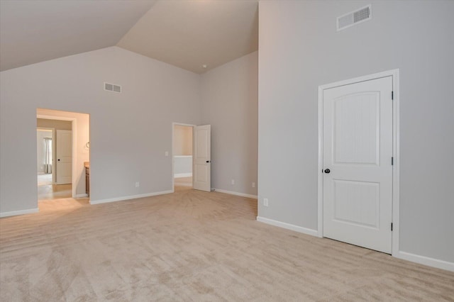 unfurnished bedroom featuring high vaulted ceiling and light colored carpet