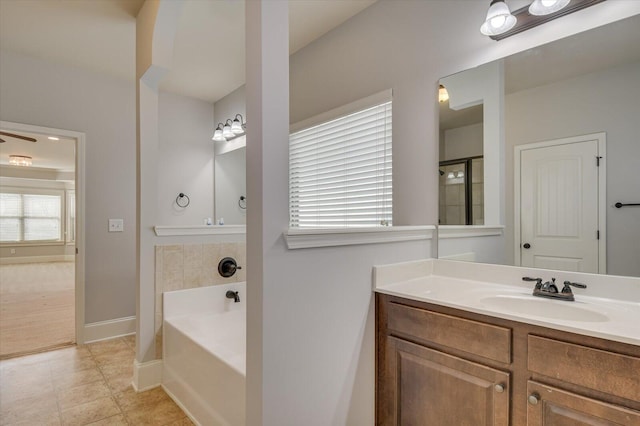 bathroom with tile patterned flooring, vanity, and a washtub