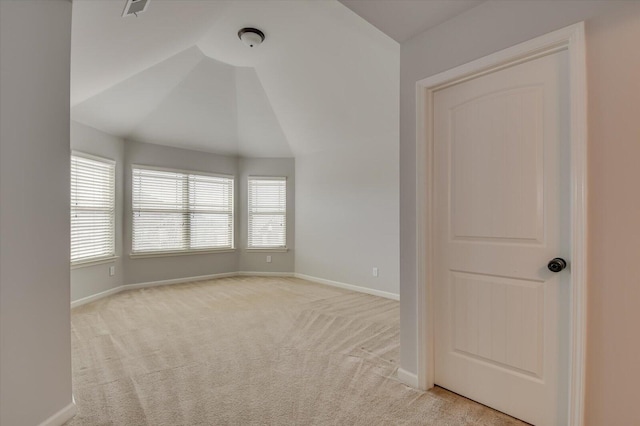 carpeted empty room with lofted ceiling