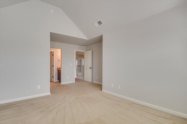 spare room featuring high vaulted ceiling and light colored carpet