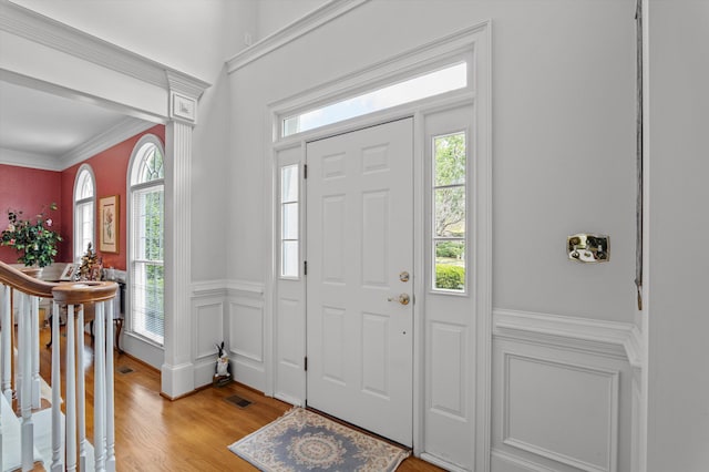 608 Saw Grass Dr, Martinez, GA 30907 - entryway featuring light wood finished floors, crown molding, visible vents, a decorative wall, and wainscoting