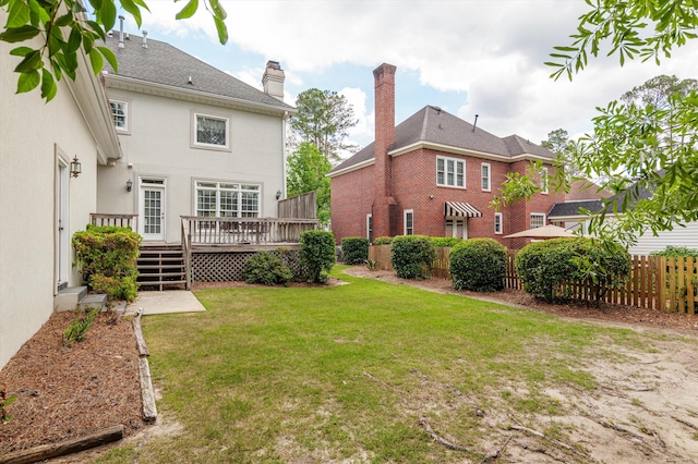 608 Saw Grass Dr, Martinez, GA 30907 - rear view of property featuring fence, a yard, stucco siding, a wooden deck, and a chimney