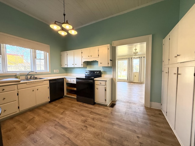 kitchen with sink, white cabinetry, decorative light fixtures, light hardwood / wood-style flooring, and black appliances