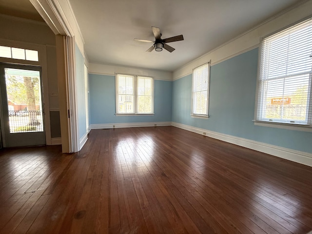 empty room with crown molding, dark wood-type flooring, and a wealth of natural light