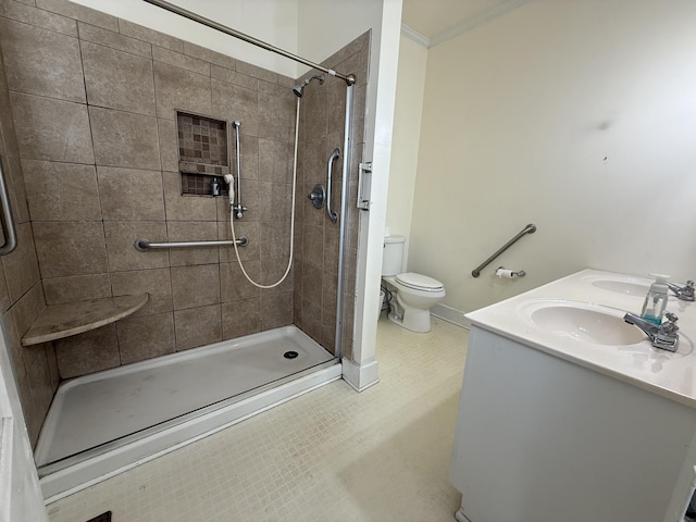 bathroom with vanity, a tile shower, crown molding, and toilet