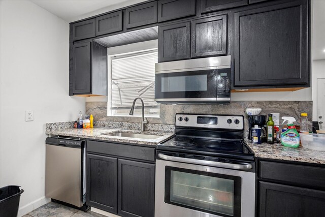 2156 Telfair St, Augusta, GA 30904 - kitchen featuring stainless steel appliances, a sink, baseboards, light stone counters, and decorative backsplash