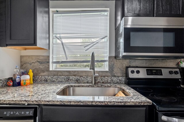 2156 Telfair St, Augusta, GA 30904 - kitchen featuring appliances with stainless steel finishes, a sink, backsplash, and light stone countertops