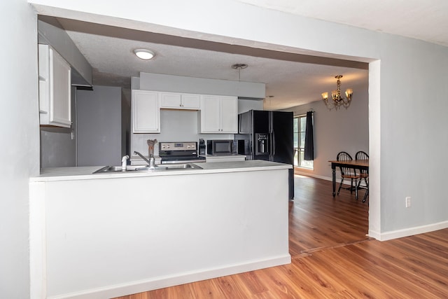 2383 Wheeless Rd, Augusta, GA 30906 - kitchen featuring black fridge, stainless steel range with electric stovetop, a peninsula, white cabinets, and light wood-style floors