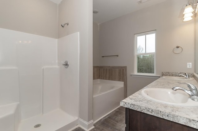 full bath featuring a shower, a bath, double vanity, and wood finished floors
