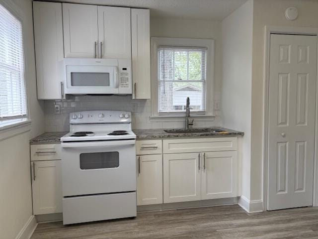 2315 Ridge Rd, Augusta, GA 30906 - kitchen with white appliances, tasteful backsplash, stone counters, light wood-style floors, and white cabinetry