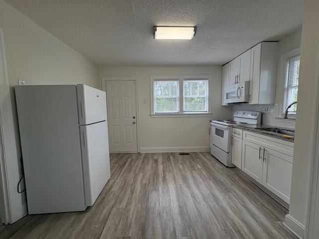 2315 Ridge Rd, Augusta, GA 30906 - kitchen with white appliances, light wood finished floors, a textured ceiling, white cabinetry, and dark countertops