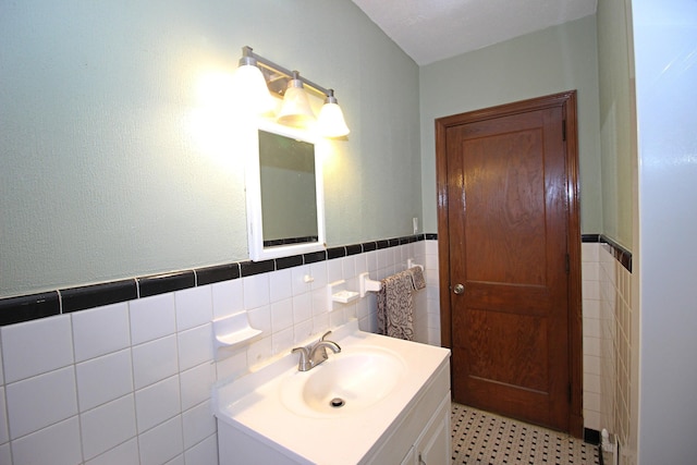 bathroom featuring vanity and tile walls