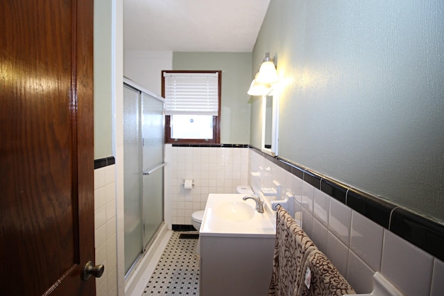 bathroom featuring vanity, toilet, tile walls, and walk in shower