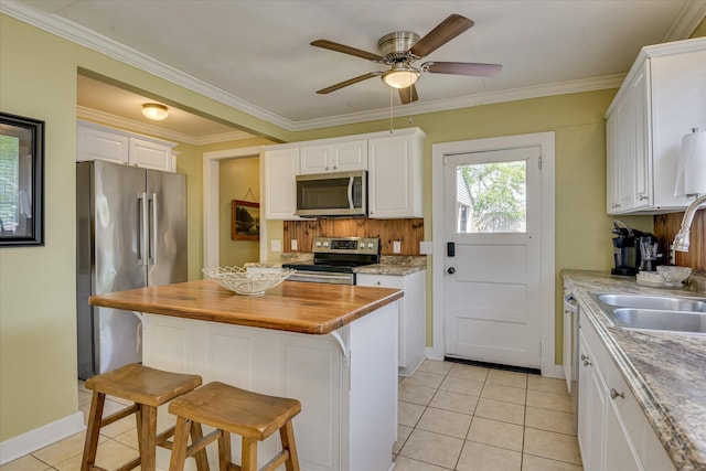 1743 King Woods Dr, Augusta, GA 30904 - kitchen with appliances with stainless steel finishes, wood counters, white cabinets, light tile patterned flooring, and ceiling fan
