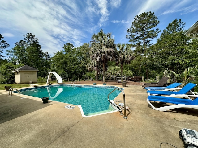 3129 Goolsby Rd, Blythe, GA 30805 - outdoor pool featuring a patio area, view of wooded area, and a water slide
