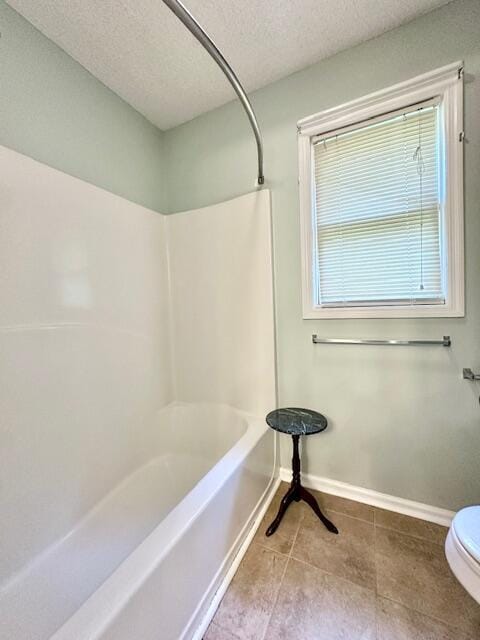 3129 Goolsby Rd, Blythe, GA 30805 - bathroom featuring a textured ceiling, tile patterned flooring, toilet, baseboards, and shower / bathtub combination