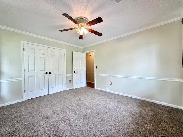 3129 Goolsby Rd, Blythe, GA 30805 - unfurnished bedroom featuring a textured ceiling, crown molding, a closet, carpet flooring, and ceiling fan