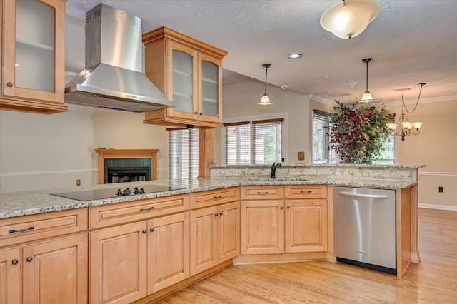 3129 Goolsby Rd, Blythe, GA 30805 - kitchen with stainless steel dishwasher, wall chimney exhaust hood, light wood finished floors, hanging light fixtures, and light stone counters