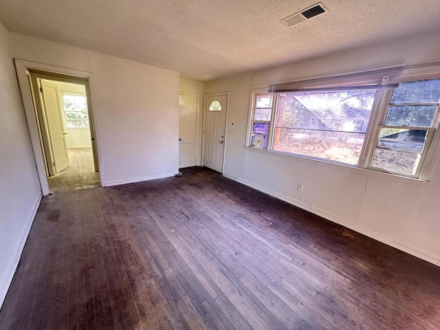 foyer with a textured ceiling and dark hardwood / wood-style flooring