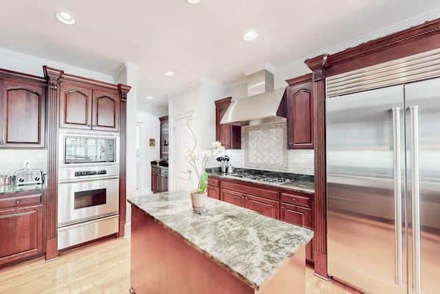 114 Altamaha Dr, North Augusta, SC 29841 - kitchen with built in appliances, a warming drawer, wall chimney range hood, light stone countertops, and crown molding