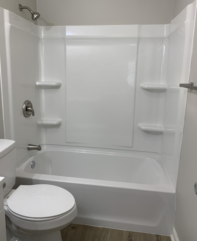 bathroom featuring hardwood / wood-style floors, shower / bathtub combination, and toilet