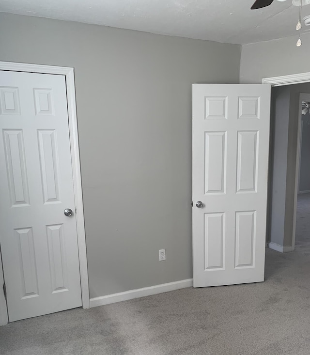 unfurnished bedroom featuring light carpet and ceiling fan