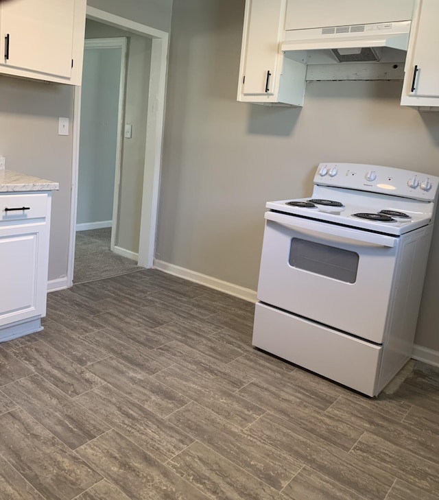 kitchen with white electric stove, dark wood-type flooring, and white cabinets