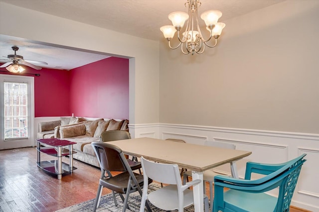 dining area with ceiling fan with notable chandelier, hardwood / wood-style floors, and a textured ceiling