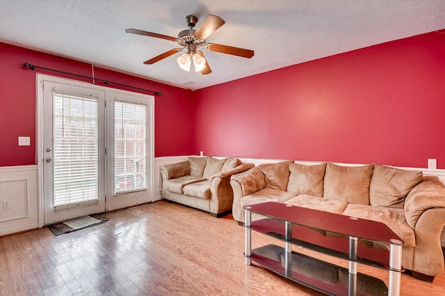 living room with light hardwood / wood-style flooring, a textured ceiling, plenty of natural light, and ceiling fan