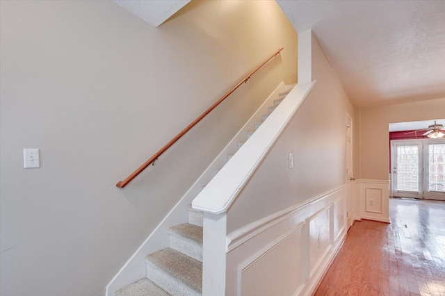 staircase featuring hardwood / wood-style flooring and ceiling fan