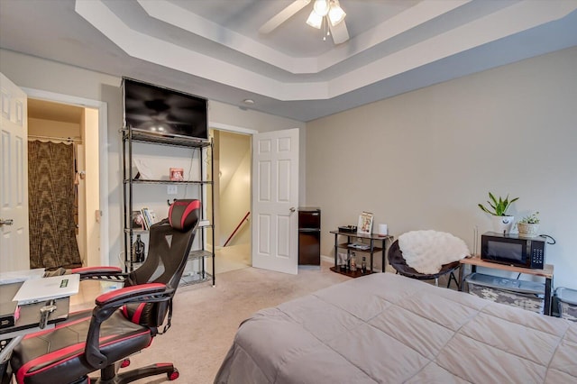 carpeted bedroom with a tray ceiling