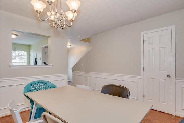 dining space featuring wood-type flooring and an inviting chandelier