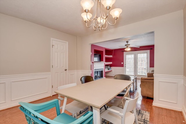 dining room featuring ceiling fan with notable chandelier and hardwood / wood-style floors