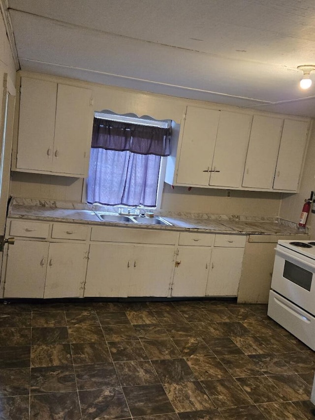 213 Whitehead St, Thomson, GA 30824 - kitchen with white range with electric stovetop, light countertops, and a sink